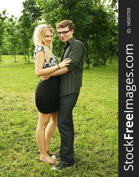 Young man and girl embracing outdoor summer time