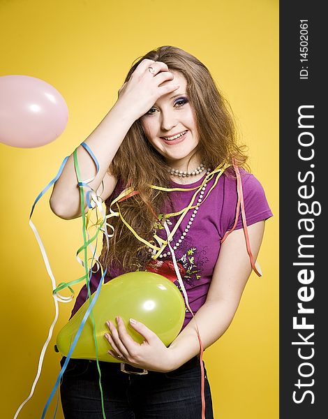Young pretty girl with balloons and paper streamer in studio