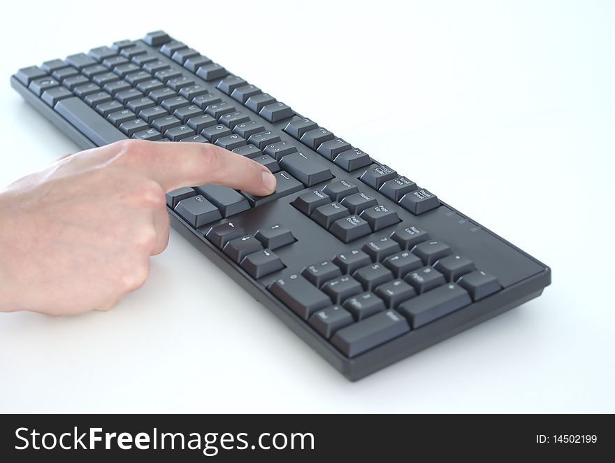 A keyboard with a hand, pressing enter. A keyboard with a hand, pressing enter