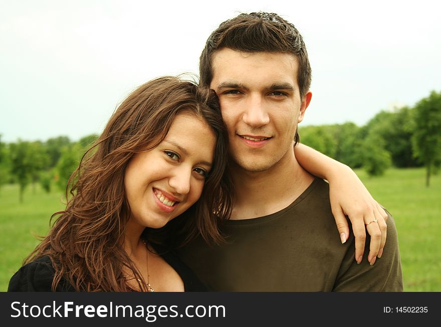 Young man and girl embracing outdoor summer time