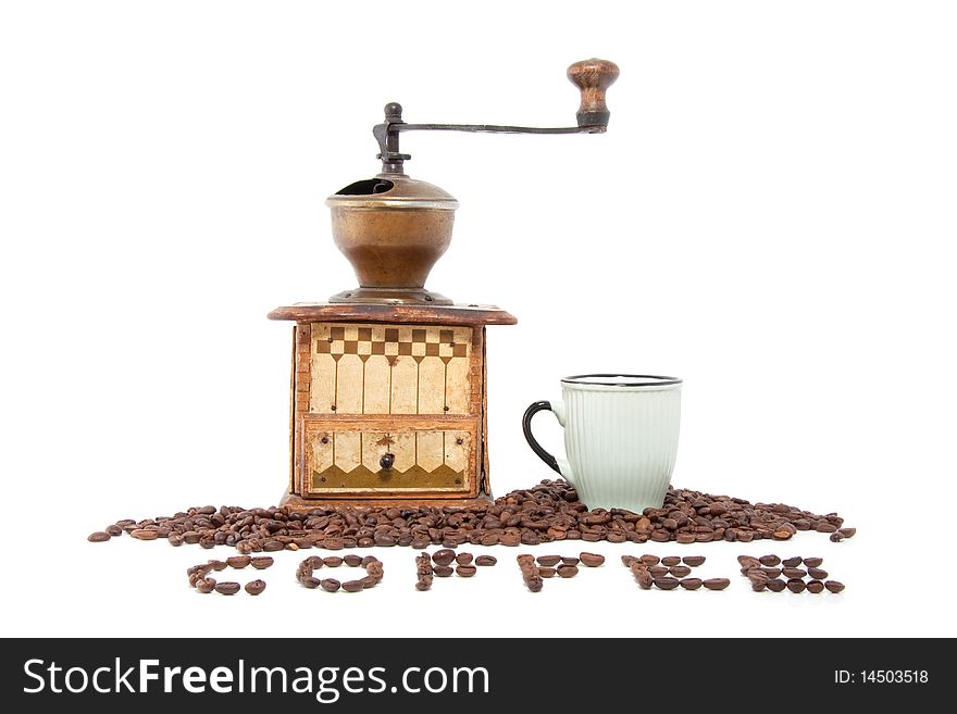An antique coffee grinder and a cup with many coffee beans in front isolated over white