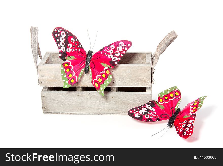Two colorful butterflies on a wooden box isolated over white