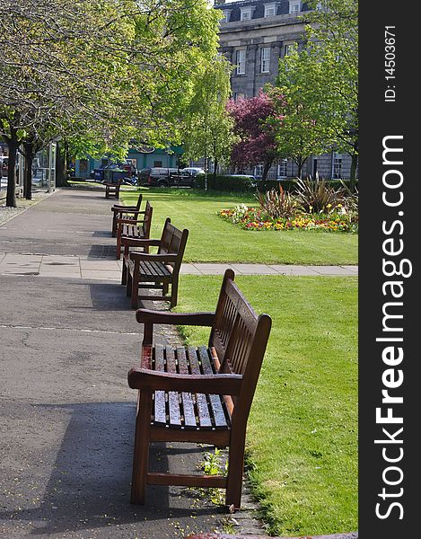 Row of empty bench in park in the middle of city, Edinburgh