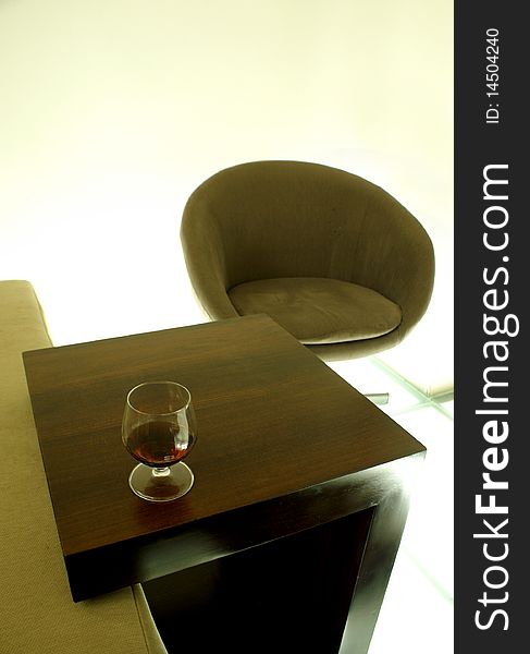 Chillout luxury nightbar club with futuristic furnitures glass floor and wooden table with glass of porto/wine on it. Chillout luxury nightbar club with futuristic furnitures glass floor and wooden table with glass of porto/wine on it
