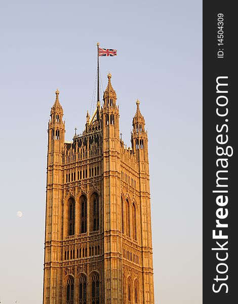 United Kingdom flag on Houses of Parliament from London, blue sky in background. United Kingdom flag on Houses of Parliament from London, blue sky in background