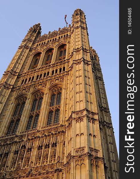 United Kingdom flag on Houses of Parliament from London, blue sky in background. United Kingdom flag on Houses of Parliament from London, blue sky in background