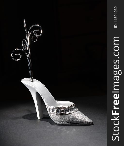 Low key image of a shoe shaped jewellery stand. Low key image of a shoe shaped jewellery stand