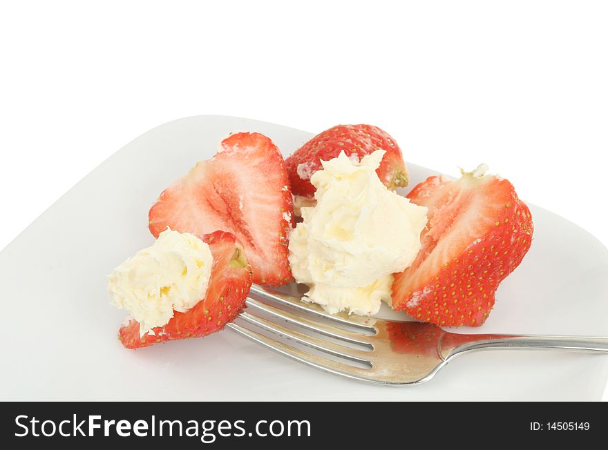 Strawberries and cream with a fork on a plate. Strawberries and cream with a fork on a plate
