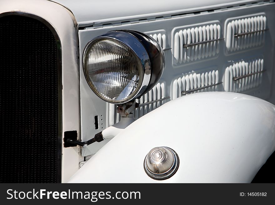 Headlight in white vintage car, closeup
