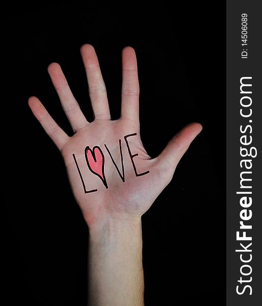 The word love written on a teenager's white Caucasian hand isolated on black background. The word love written on a teenager's white Caucasian hand isolated on black background.