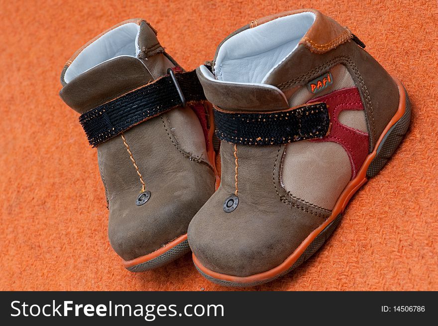 Children shoes on a orange background. Children shoes on a orange background