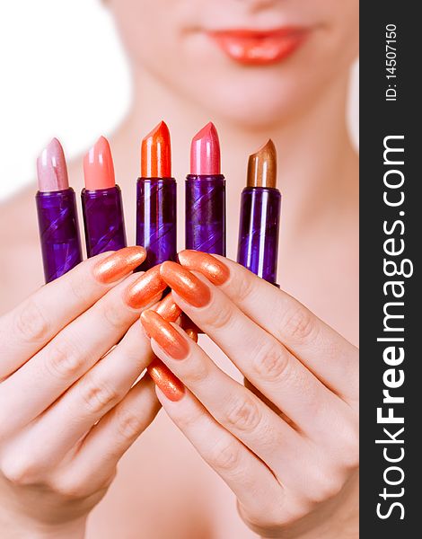 Beautiful girl holding five lipsticks of different colours