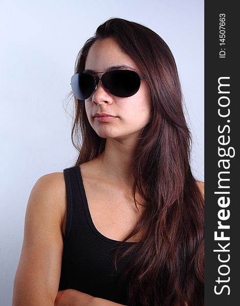 Portrait of a beautiful young woman with long brown hair wearing black shirt and sunglasses. Portrait of a beautiful young woman with long brown hair wearing black shirt and sunglasses