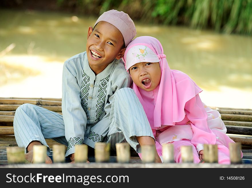 Muslim kids sitting by the pond. Muslim kids sitting by the pond