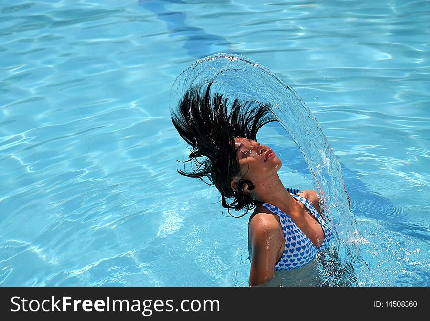 Young lady splashing/flipping her hair in the water. Young lady splashing/flipping her hair in the water