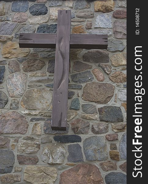 Wooden cross on stone wall background. Wooden cross on stone wall background