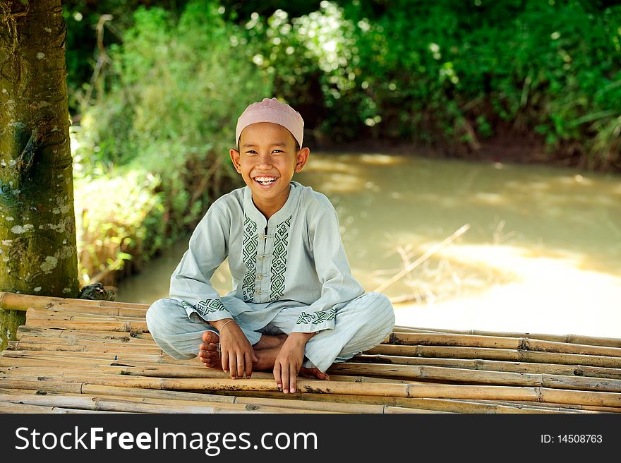 Happy Indonesian boy , sitting on bamboo. Happy Indonesian boy , sitting on bamboo