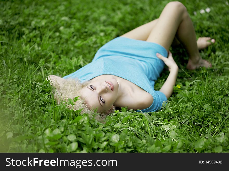 The image of a beautiful girl lying on the grass