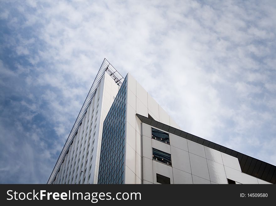 Detail shot of an office building in Tokyo, with triangular composition and shot against a beautiful slightly overcast blue sky. Detail shot of an office building in Tokyo, with triangular composition and shot against a beautiful slightly overcast blue sky.