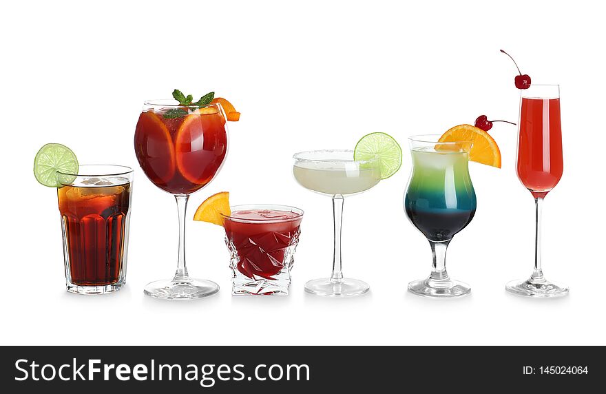 Glasses of traditional alcoholic cocktails on white background