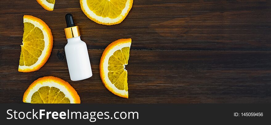 White Vitamin C Bottle And Oil Made From Orange Fruit Extract, Mockup Of Beauty Product Brand. Top View On The Wood Background.