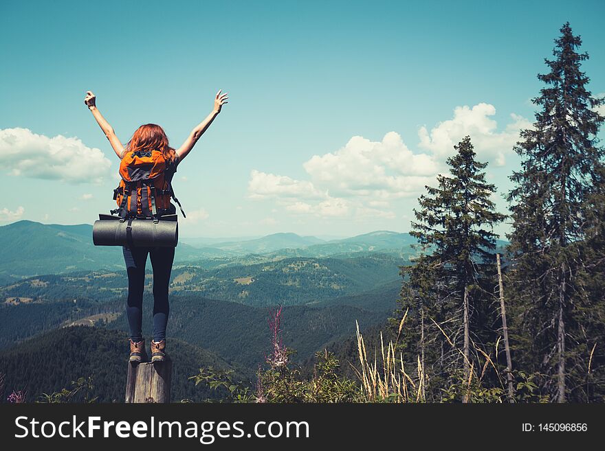 Girl hiker with a backpack standing on the background of mountains and forests. Carpathians, Ukrainian landscape. Girl hiker with a backpack standing on the background of mountains and forests. Carpathians, Ukrainian landscape