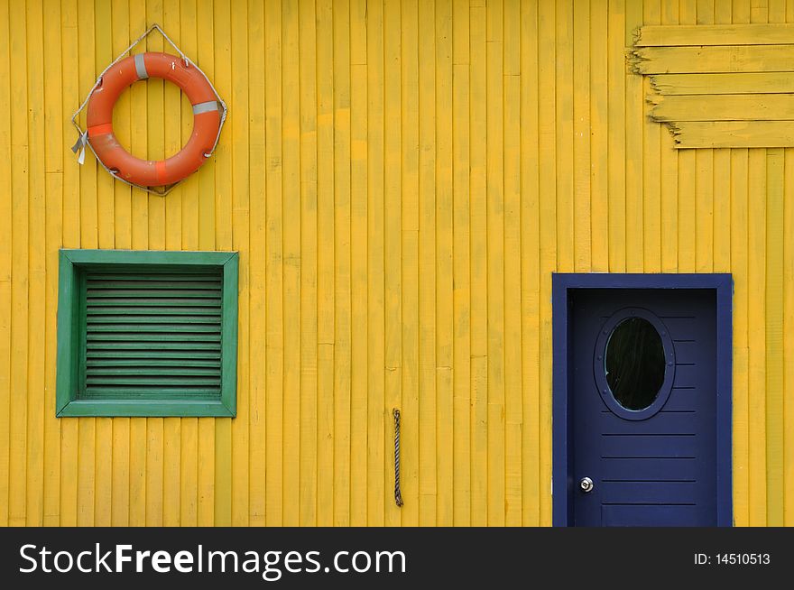 Wooden cabin external, composed by colors and different shape in door and window.