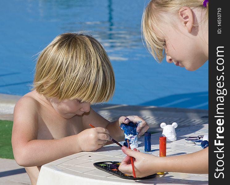 A little girls draws near the pool. A little girls draws near the pool