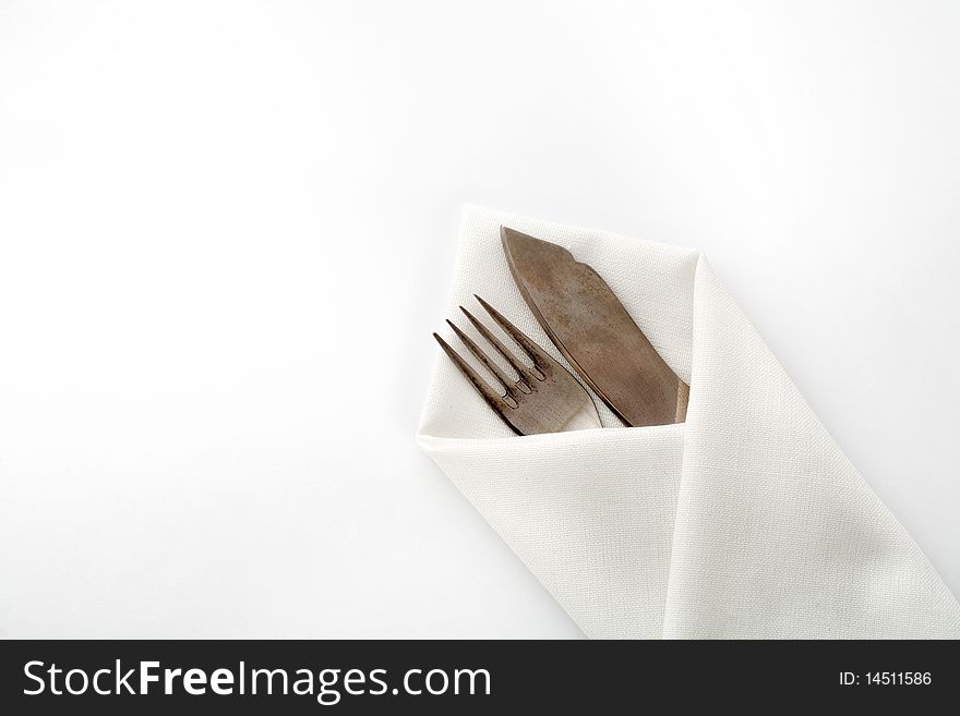 An image of a fork and knife in napkin