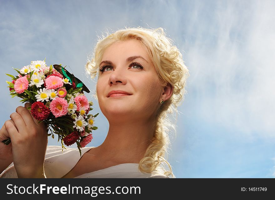 Lovely woman with a butterfly over blue sky