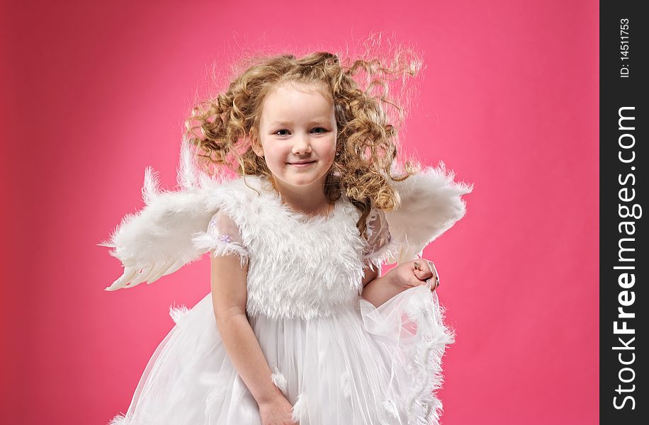 Beautiful little angel girl isolated on pink background