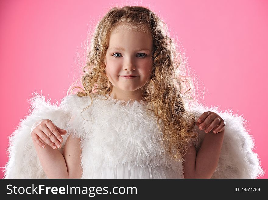 Beautiful little angel girl isolated on pink background