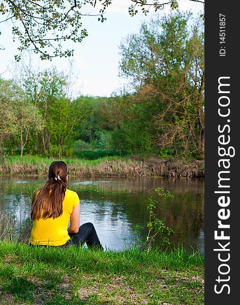 Girl sitting on the bank of the river. Girl sitting on the bank of the river