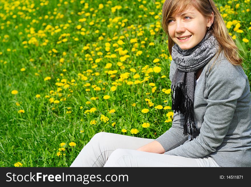 The girl sits on a grass