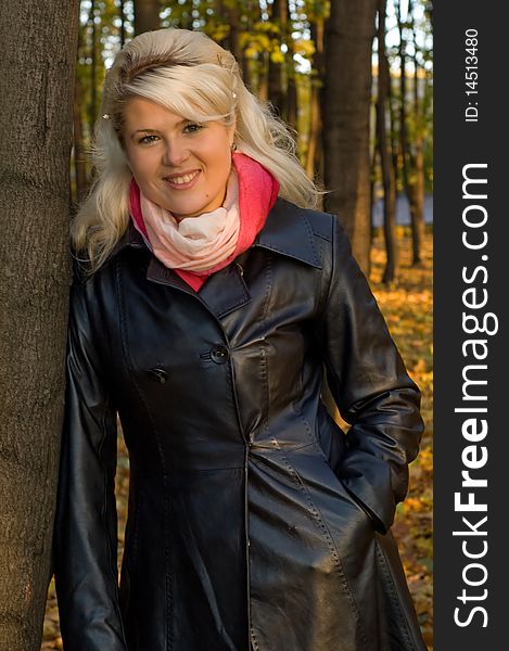 Woman in a leather coat walks in autumn park. Woman in a leather coat walks in autumn park