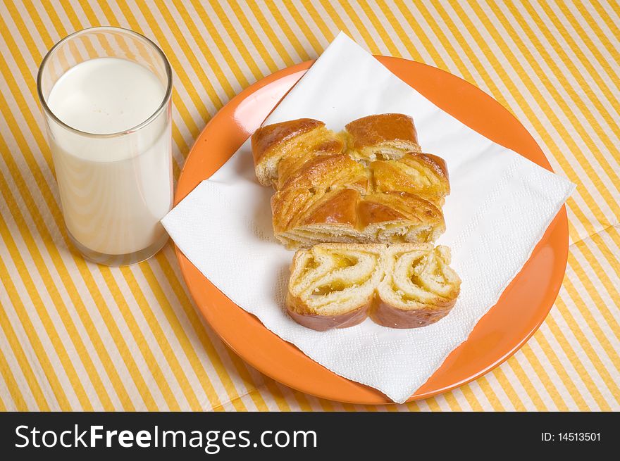 Glass of milk and pieces of sweet pie with poppy seeds on a table