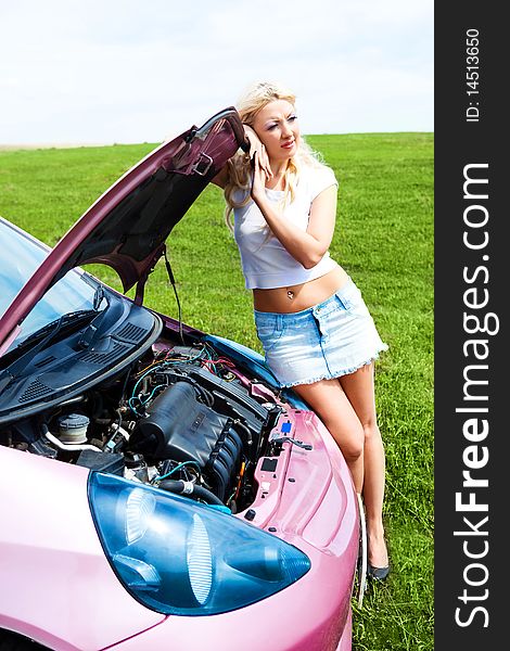 Beautiful young woman repairing her car outdoor on a summer day. Beautiful young woman repairing her car outdoor on a summer day