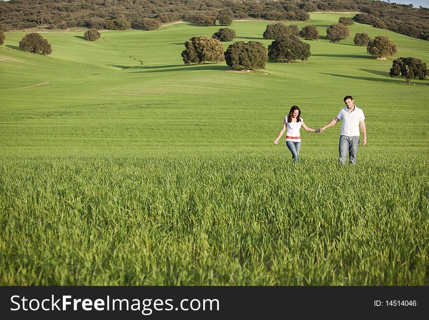 Young beautiful couple hand by hand on natural background. Young beautiful couple hand by hand on natural background.