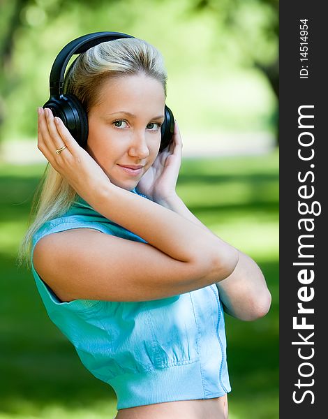 Girl with headphones in park, outdoors