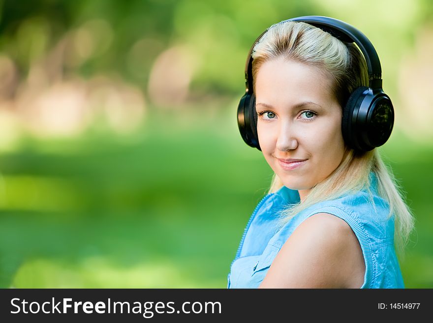 Girl listening music on headphones in park