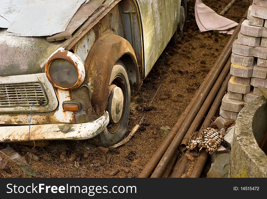 Wrecked vintage german plastic car in dirty yard. Wrecked vintage german plastic car in dirty yard