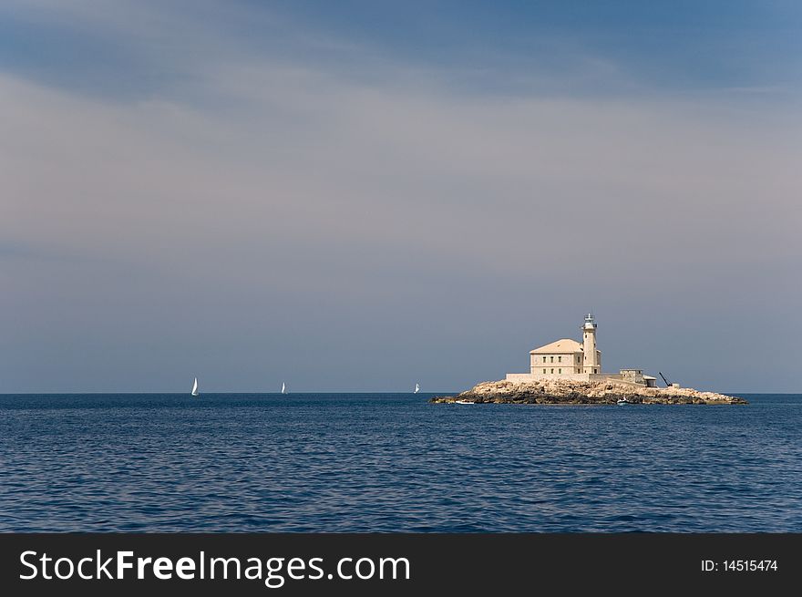 Old lighthouse on little island under beautiful sky. Old lighthouse on little island under beautiful sky