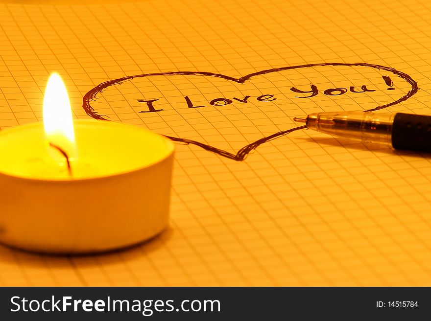 Inscription I Love You on a sheet of notebook with candles