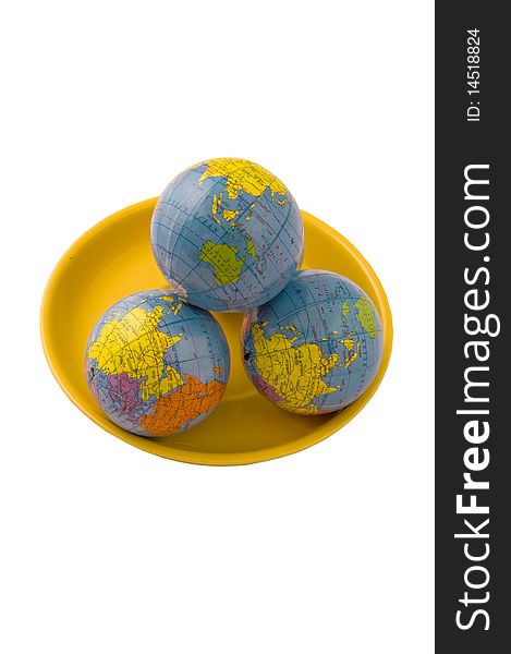 Three models of globes on the yellow plate and isolated on the white. Three models of globes on the yellow plate and isolated on the white