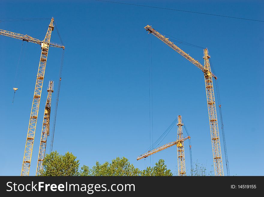 Four hoisting cranes and the sky