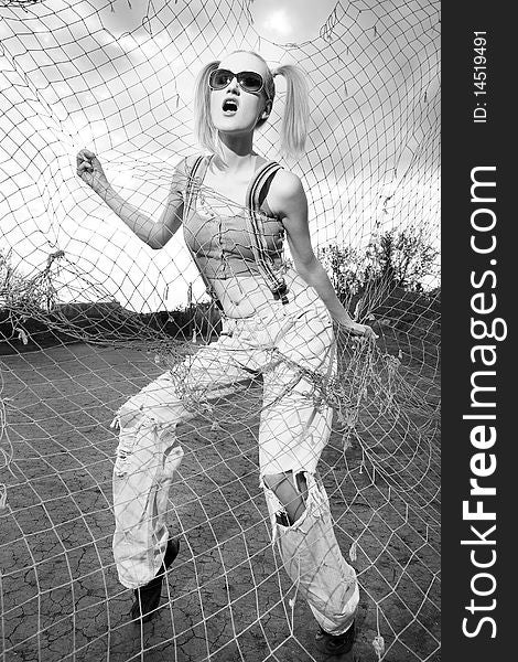 Fashion model standing behind net webbing