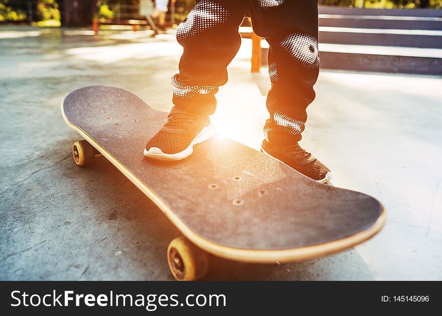 Boy legs in black shoes on the skateboard close up image. Boy legs in black shoes on the skateboard close up image