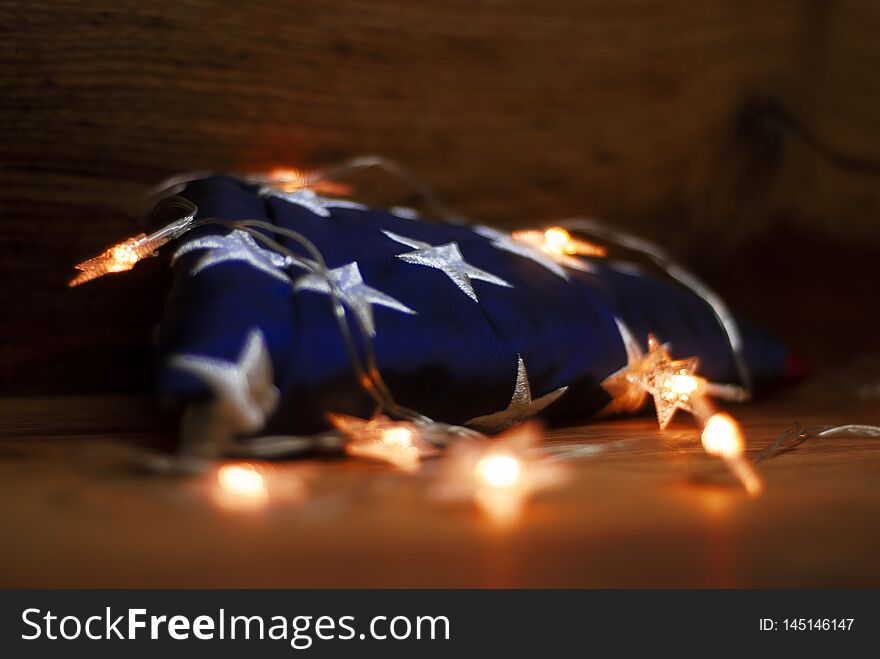 American flag with Garland on a wooden background for Memorial Day and other holidays of the United States of America.