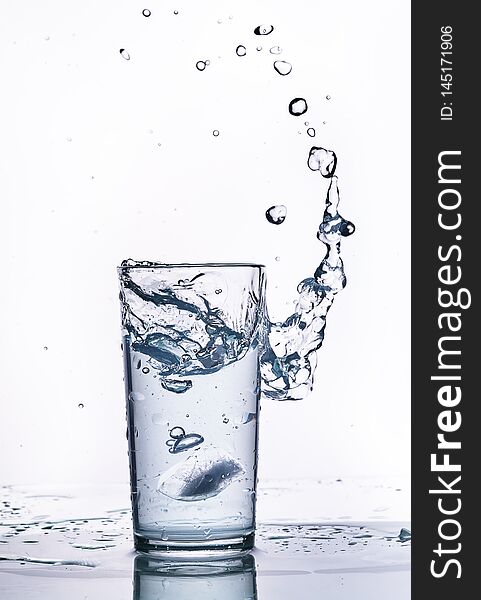 Splash of water in a glass beaker. White background