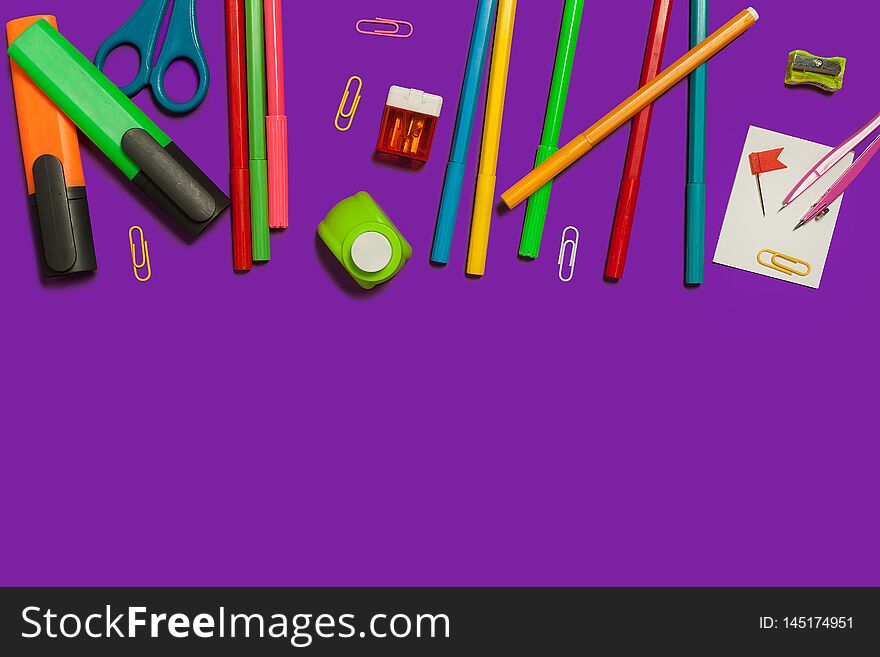 Row of various school and office supplies lying on a purple background. free space for advertising text. Row of various school and office supplies lying on a purple background. free space for advertising text